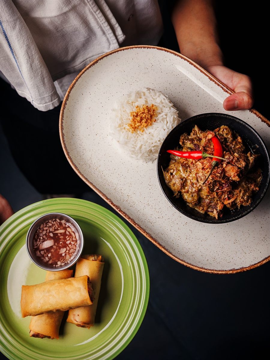 Beef rendang with rice and crisp spring rolls, served family style