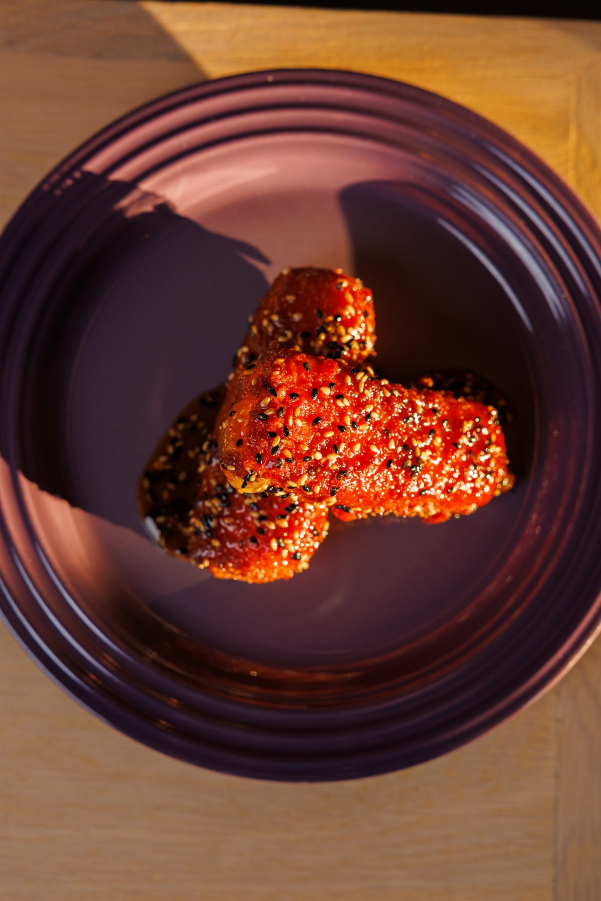 Overhead view of sesame-glazed mozzarella sticks on a purple plate